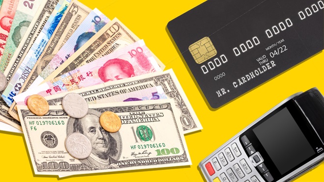 foreign currency next to a black credit_card and payment terminal